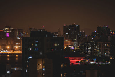 Illuminated buildings against sky at night