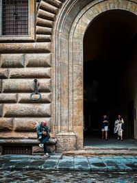 Rear view of people in front of historic building