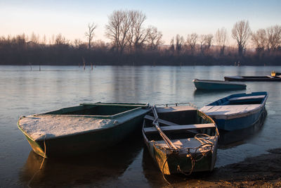 Boats moored in water against sky