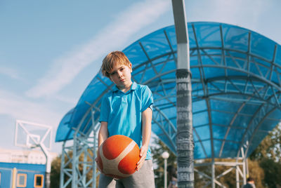 Portrait of a boy in a sports uniform with a basketball in his hands. a boy holds a ball in his hand
