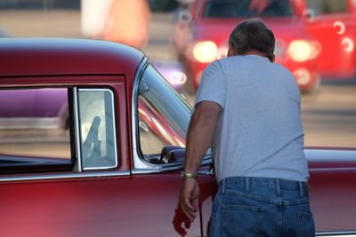 Rear view of man standing on car