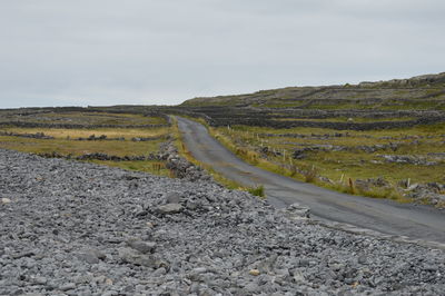 Road amidst land against sky