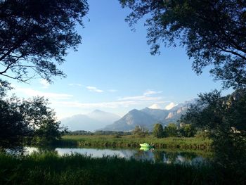 Scenic view of river and mountains against sky