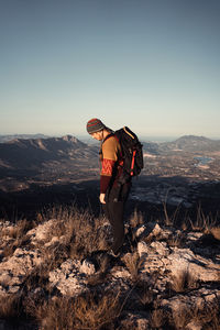 Full length of man standing on rock against sky