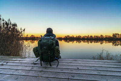 Rear view of man on snow against sky during sunset