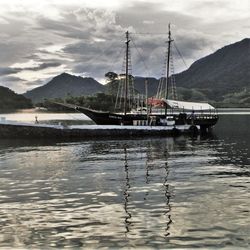 Boats in lake with mountains in background