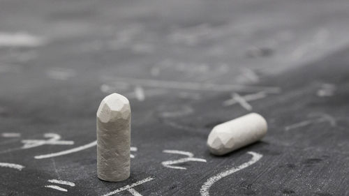 Close-up of chalks with text on blackboard