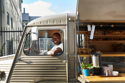 Portrait of smiling salesman sitting in food truck