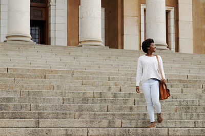 Full length of woman standing on staircase