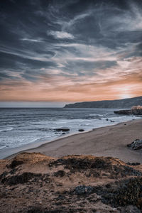 Scenic view of beach against sky during sunset