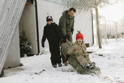 Happy family at winter outside house