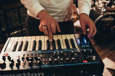 Midsection of man playing piano