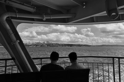 Rear view of men traveling in ferry boat