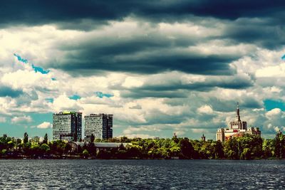 Buildings in city against cloudy sky