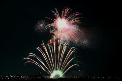 Low angle view of fireworks exploding at night