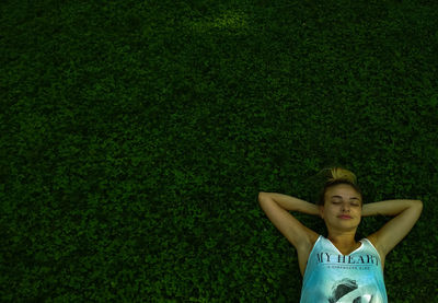 Portrait of a young woman lying on grass