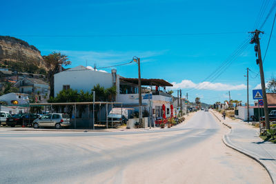 Cars on street against clear blue sky