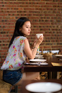 Young woman drinking glasses on table