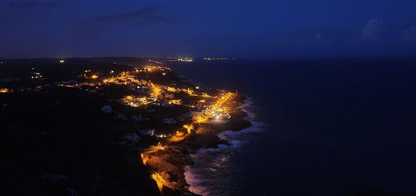 Aerial view of illuminated city against sky at night