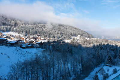 Houses in village against sky during winter