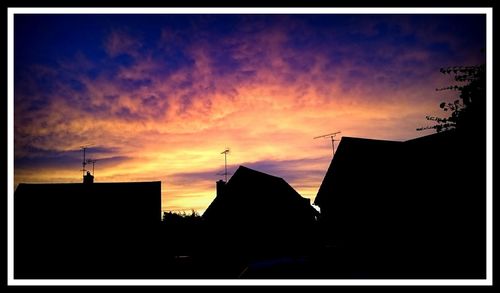 Low angle view of silhouette buildings against sky at dusk