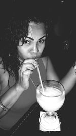Close-up portrait of woman drinking cocktail in nightclub