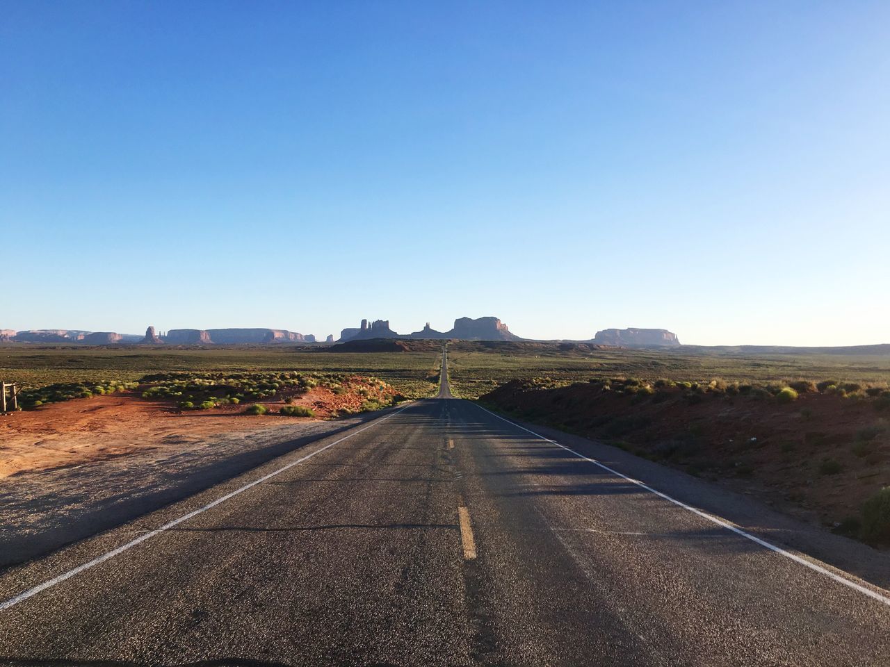 clear sky, the way forward, copy space, road, transportation, diminishing perspective, blue, landscape, country road, vanishing point, road marking, empty road, tranquil scene, empty, tranquility, field, long, asphalt, street, nature