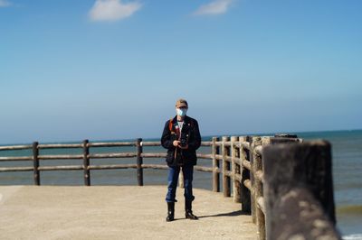 Rear view of woman walking on pier against clear sky