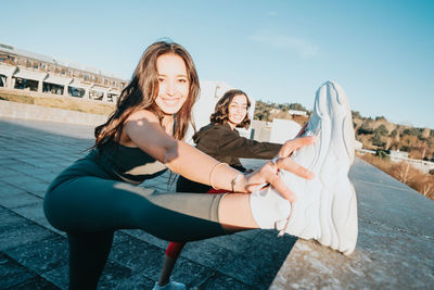 Female friends stretching outside