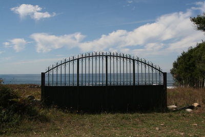 Metallic structure on field against sky