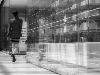 Full length of woman walking on glass window