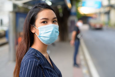 Portrait of young woman standing on street