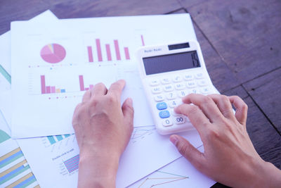 Midsection of man using mobile phone on table
