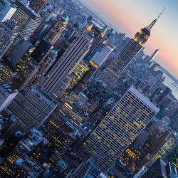 Aerial view of illuminated buildings in city against sky