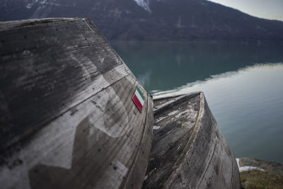 Wooden boats moored at riverbank against mountain