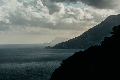 Scenic view of sea and mountains against sky