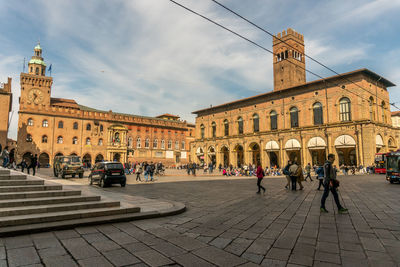 People walking on street against building in city