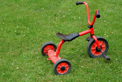 High angle view of red tricycle on field