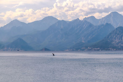 Scenic view of sea and mountains against sky