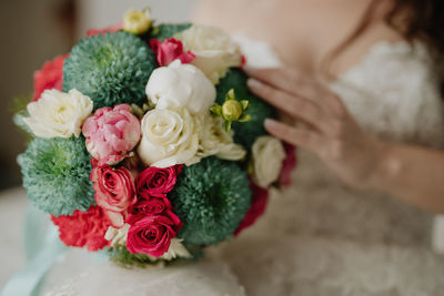 Midsection of bride holding bouquet