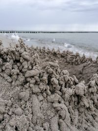 Close-up of pebbles on beach against sky