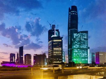 Illuminated buildings in city against sky at night