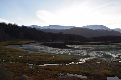 Scenic view of river and mountains against sky