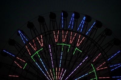 Low angle view of illuminated ferris wheel against sky at night