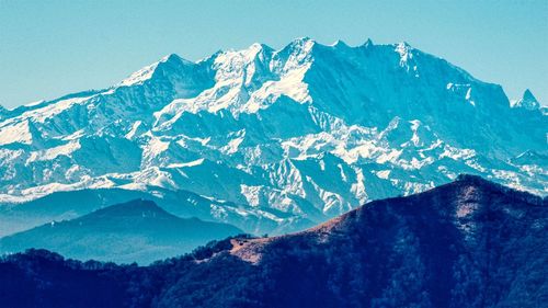 Scenic view of snowcapped mountains against blue sky