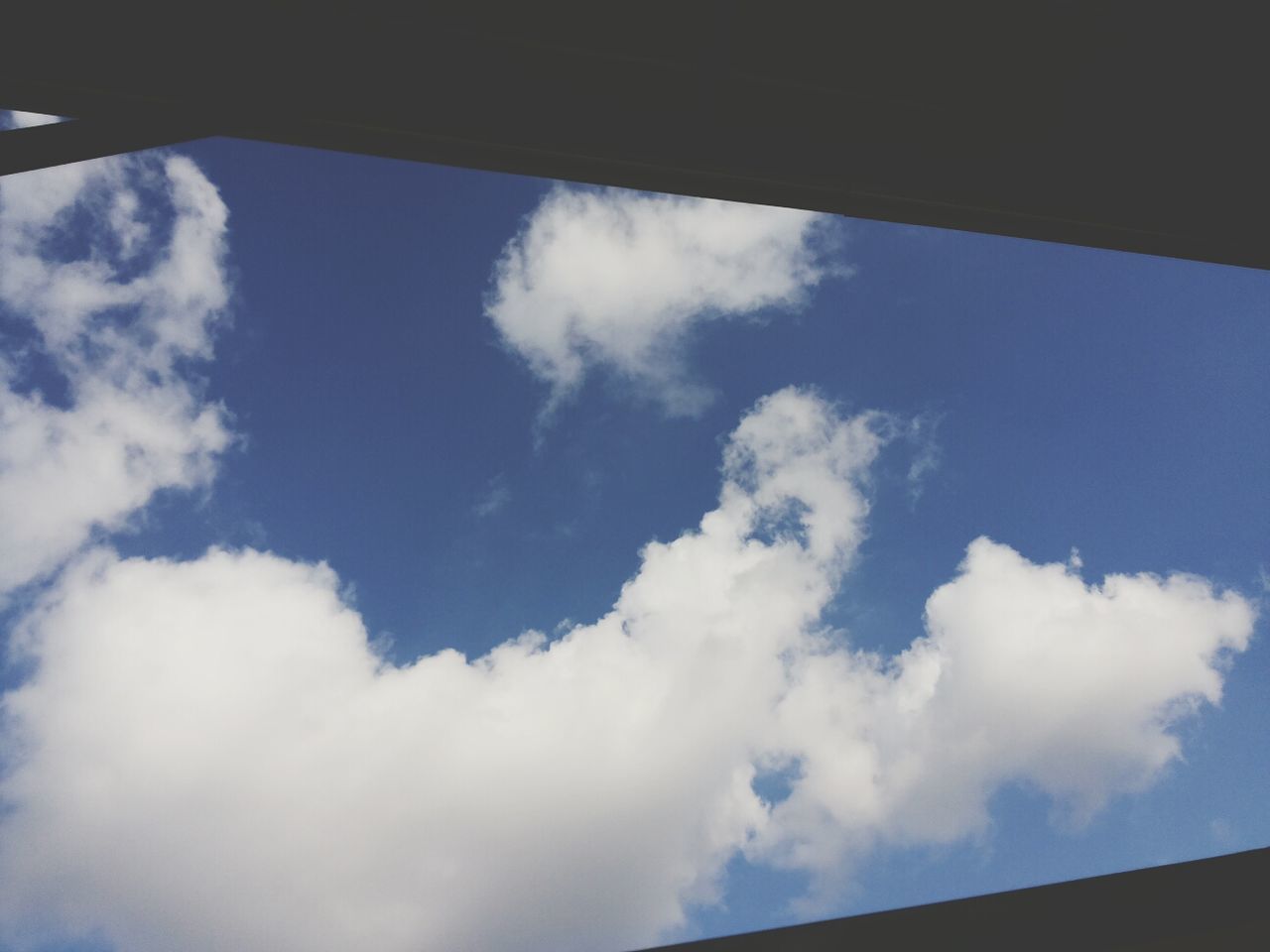 sky, low angle view, cloud - sky, cloud, blue, nature, cloudy, window, beauty in nature, day, scenics, tranquility, no people, cloudscape, outdoors, tranquil scene, white color, high section, part of, idyllic
