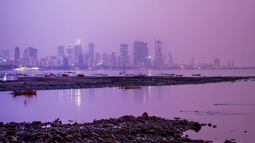 Scenic view of lake by buildings against sky