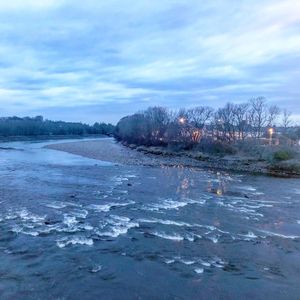 Scenic view of lake against sky during winter