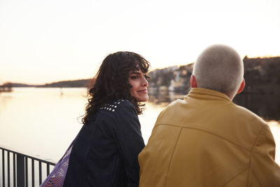 Smiling young women standing together at river