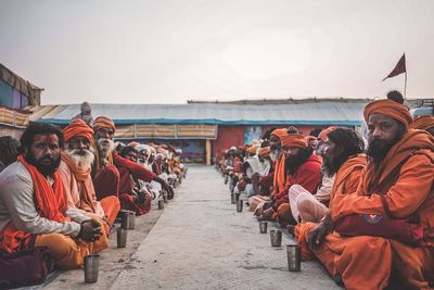 People sitting on street against sky